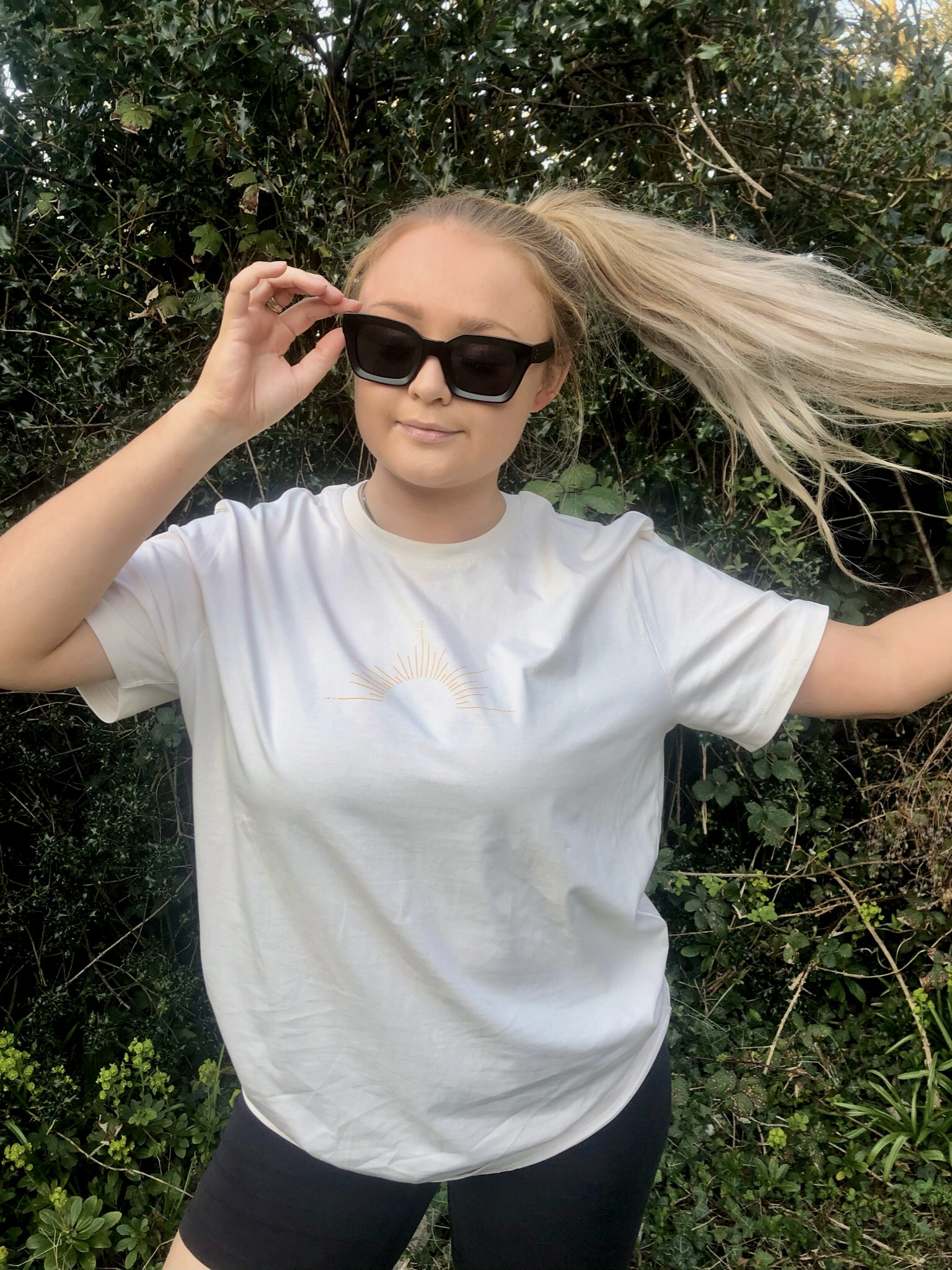 Women wearing a white t-shirt with a sun outline