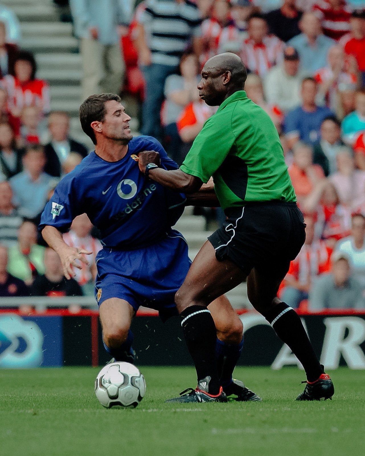 Premier League referee Uriah Rennie in an infamous confrontation with Manchester United player Roy Keane. Rennie has his hand on Keane's shirt.