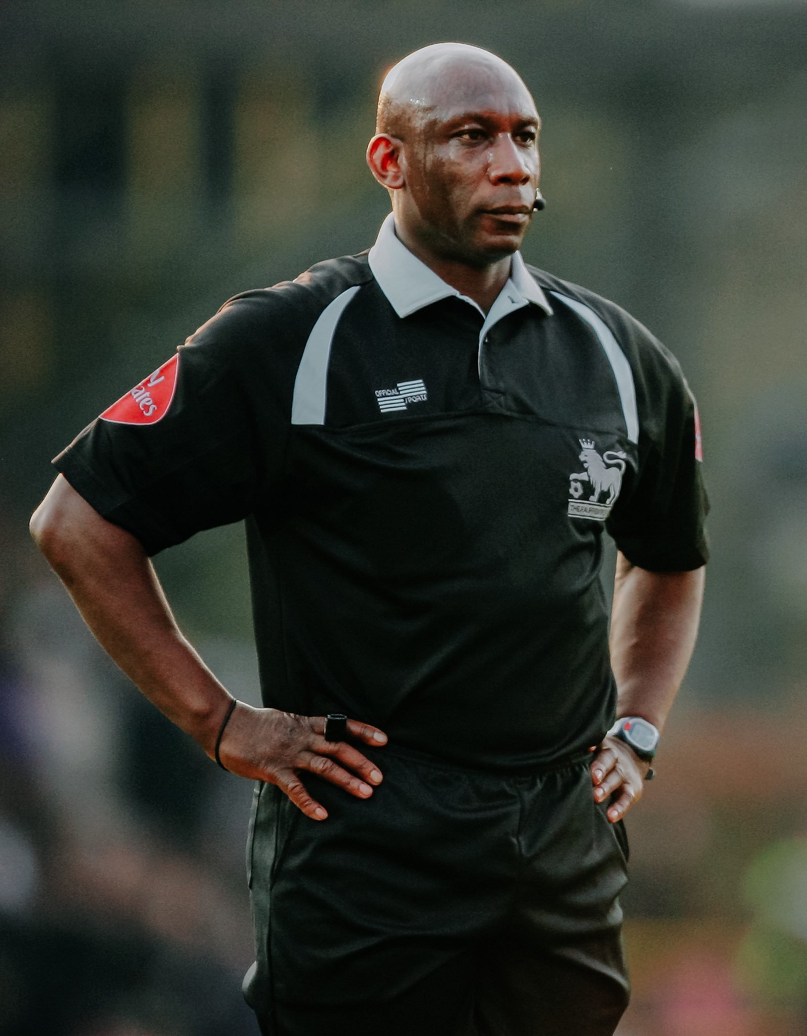 Football Referee Uriah Rennie stands dressed in football kit with his hands on his sides.