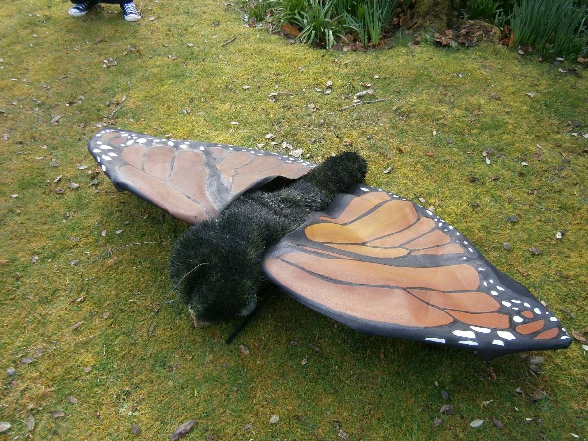 Large model of an orange butterfly on grass.