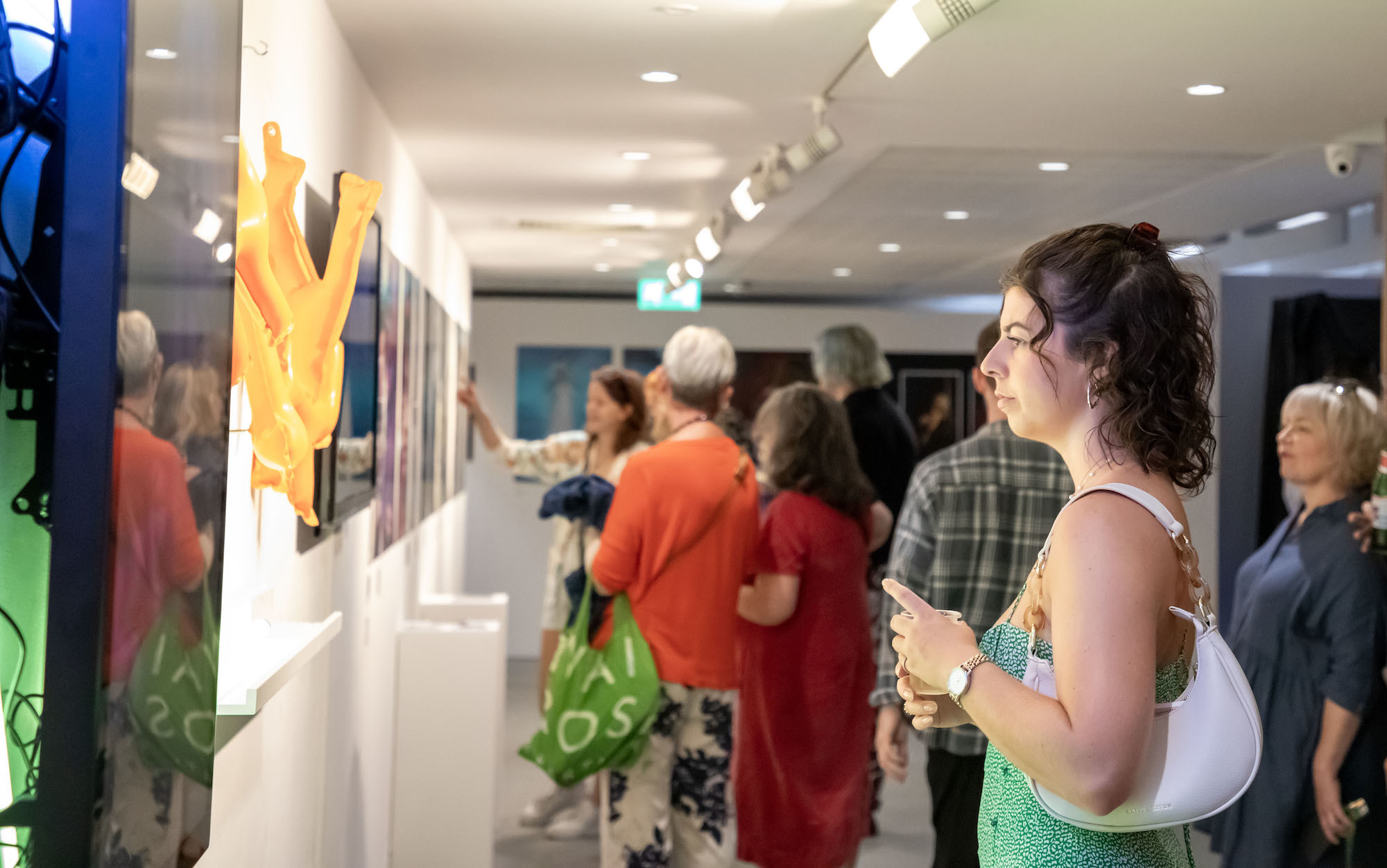 A group of people standing in a space at TheGallery during the 2023 Snapshot shows and looking at exhibits