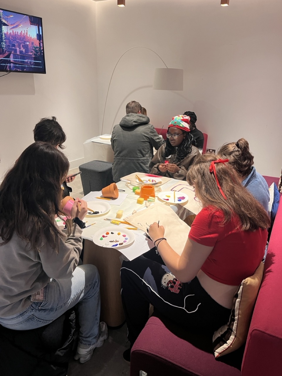 Students gathered round a table working on arts and crafts.