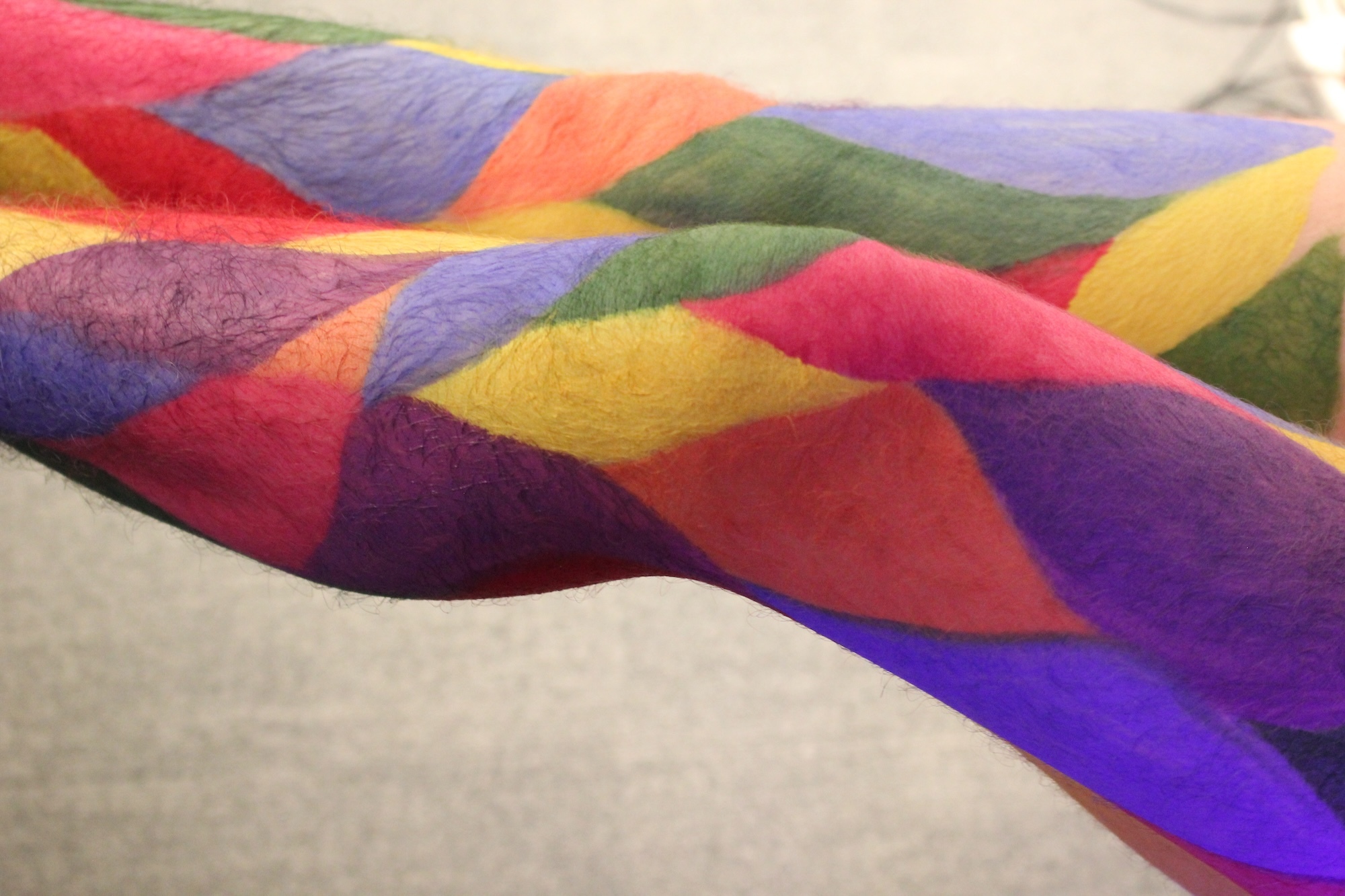 Close-up of a person's legs, painted in a colourful harlequin style.
