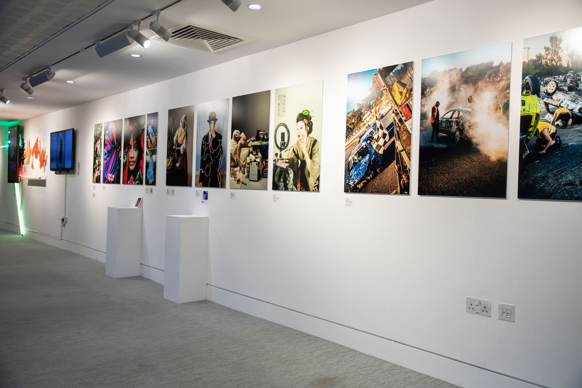 A wall of TheGallery at AUB lined with an assortment of photograph prints.