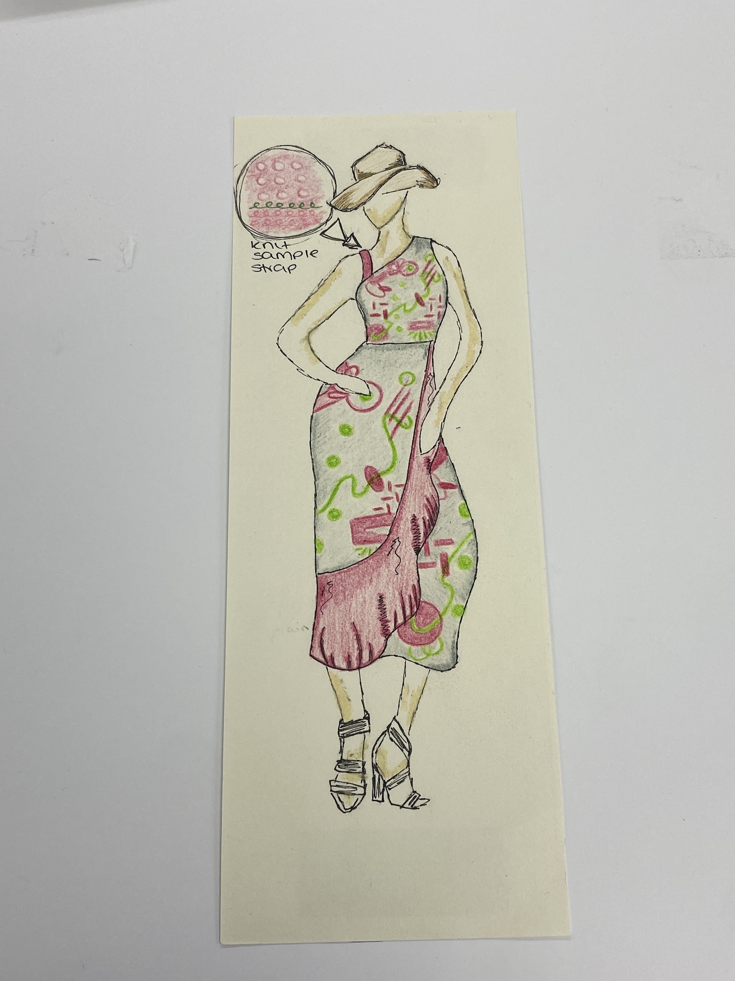 Sketch of figure in pink hat and green dress with pink details on cream paper. Black ink outlines with watercolour washes.