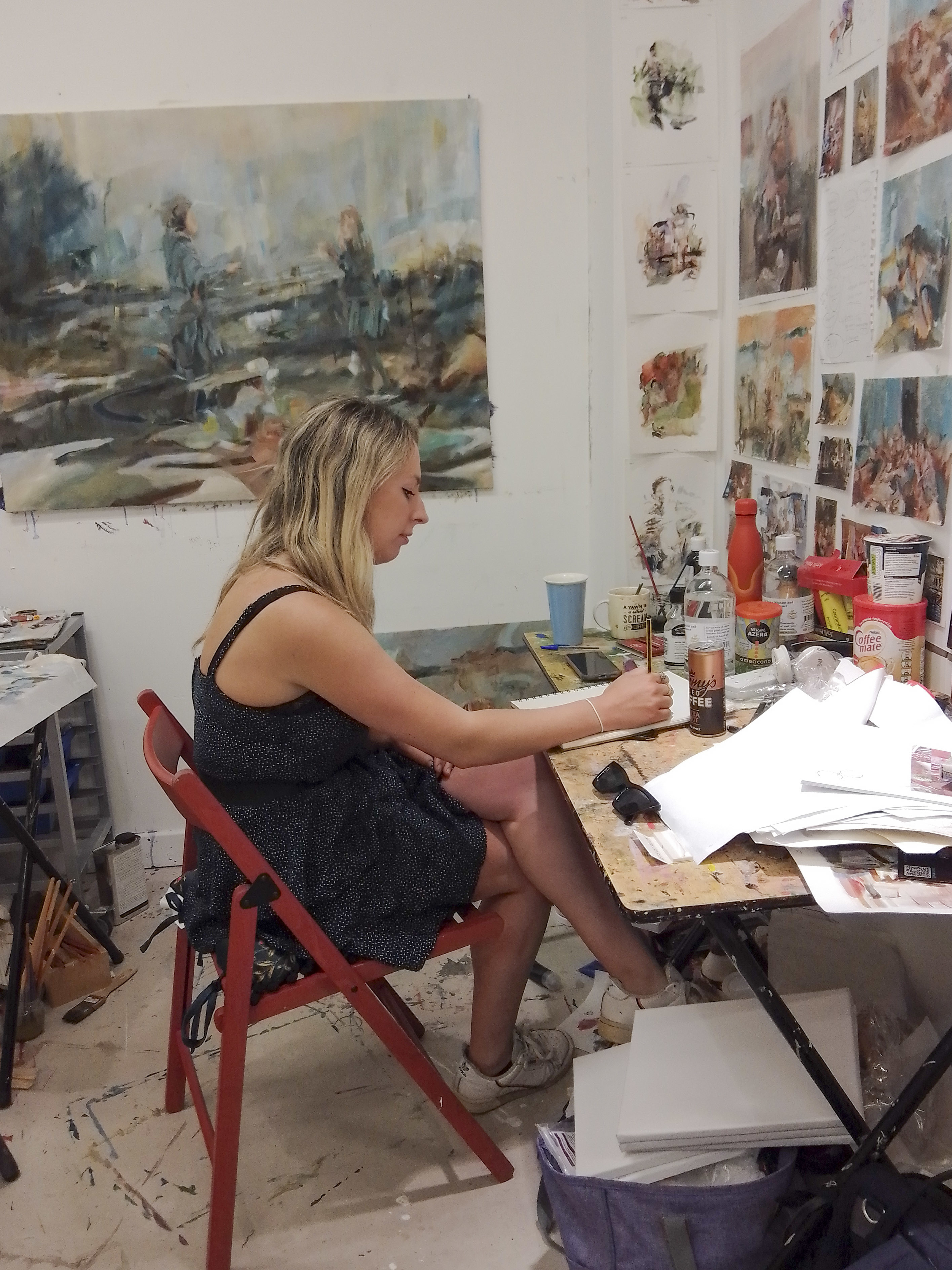MA Painting student, Ella sitting in her workspace surrounded by painting tools