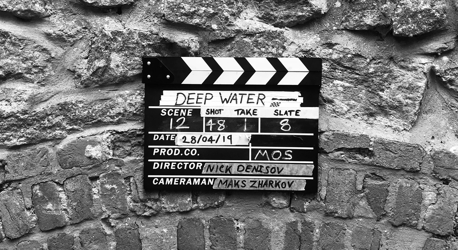 Clapper board lying on a stone floor. Film title reads "Deep Water".