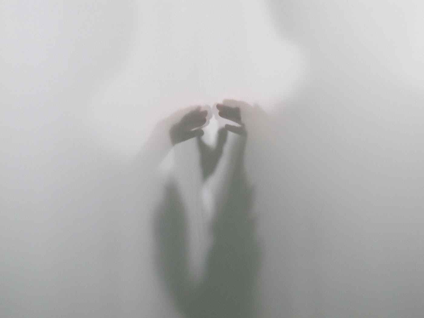 Two faint silhouettes prepare to touch hands.