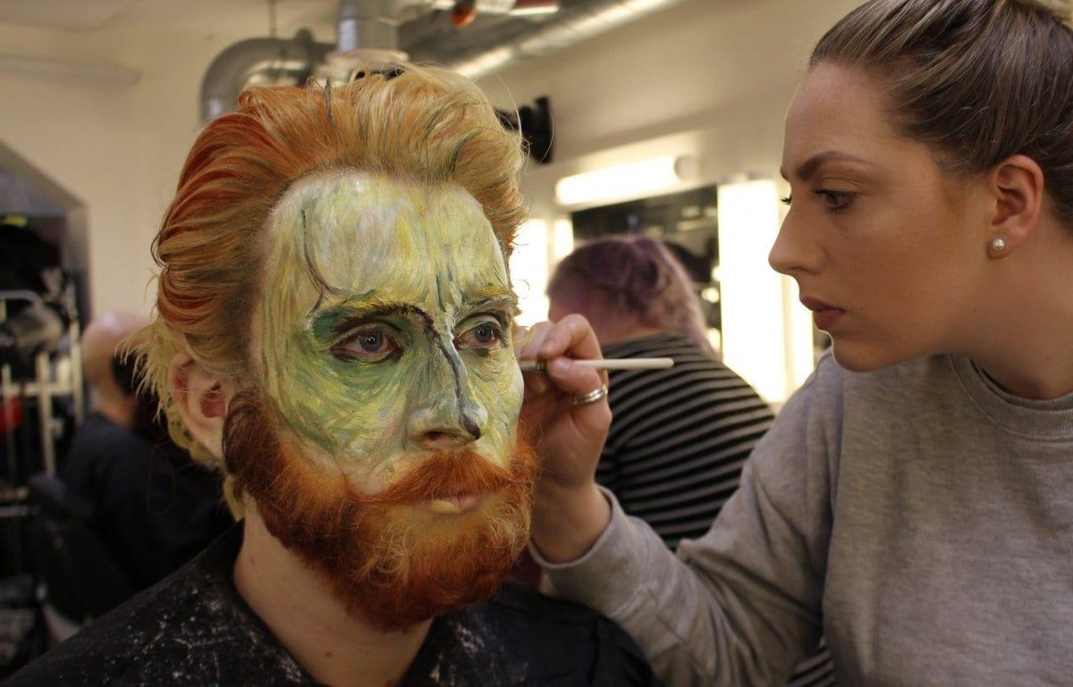Make-up student painting an Acting student's face for a performance
