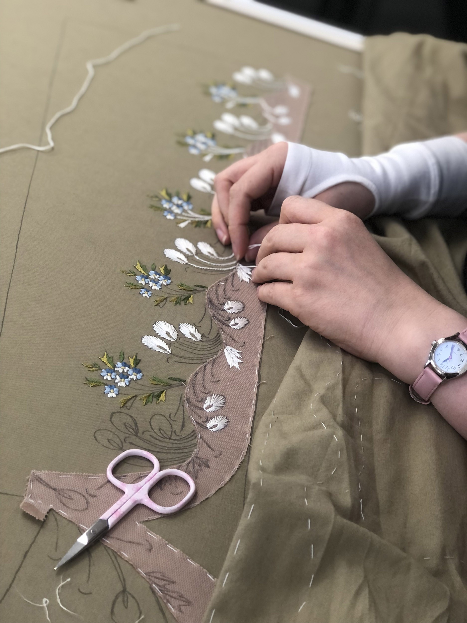 Hands embroidering flowers