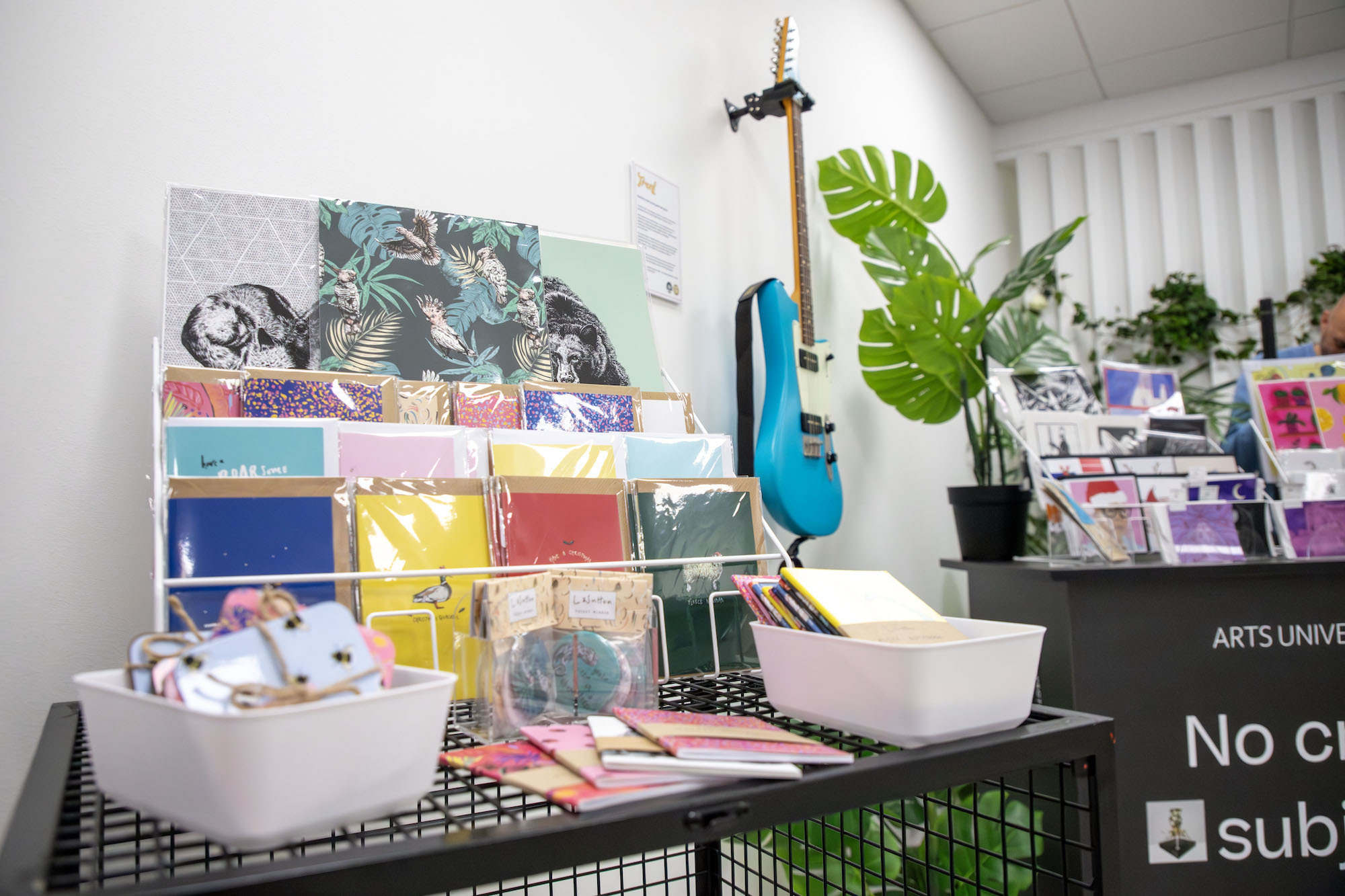 Illustrated prints and a guitar on display for sale at the #AUBMakers shop in Poole.