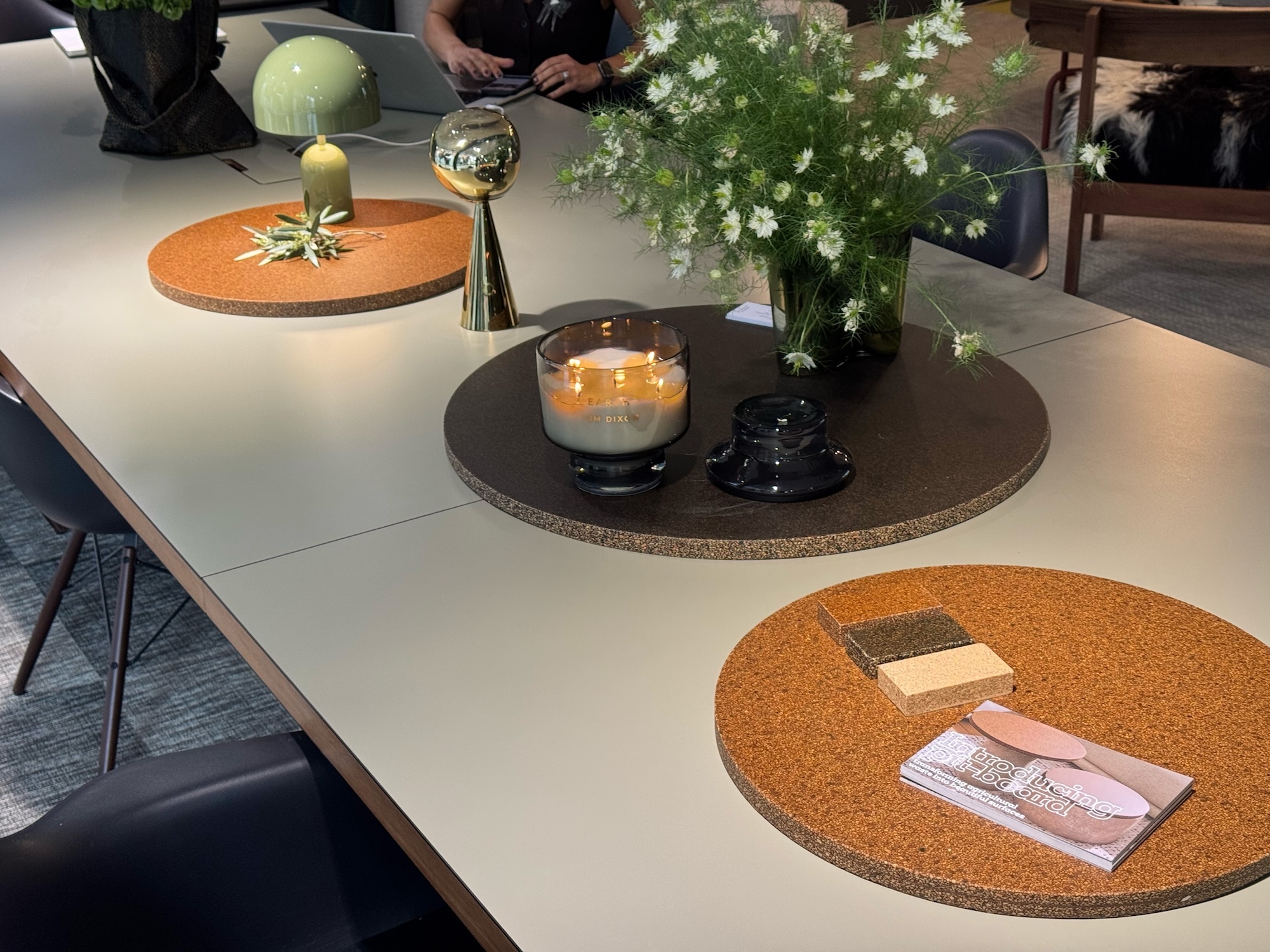 A long pair of tables with three circular place mats made of the sustainable material Pit-Board.