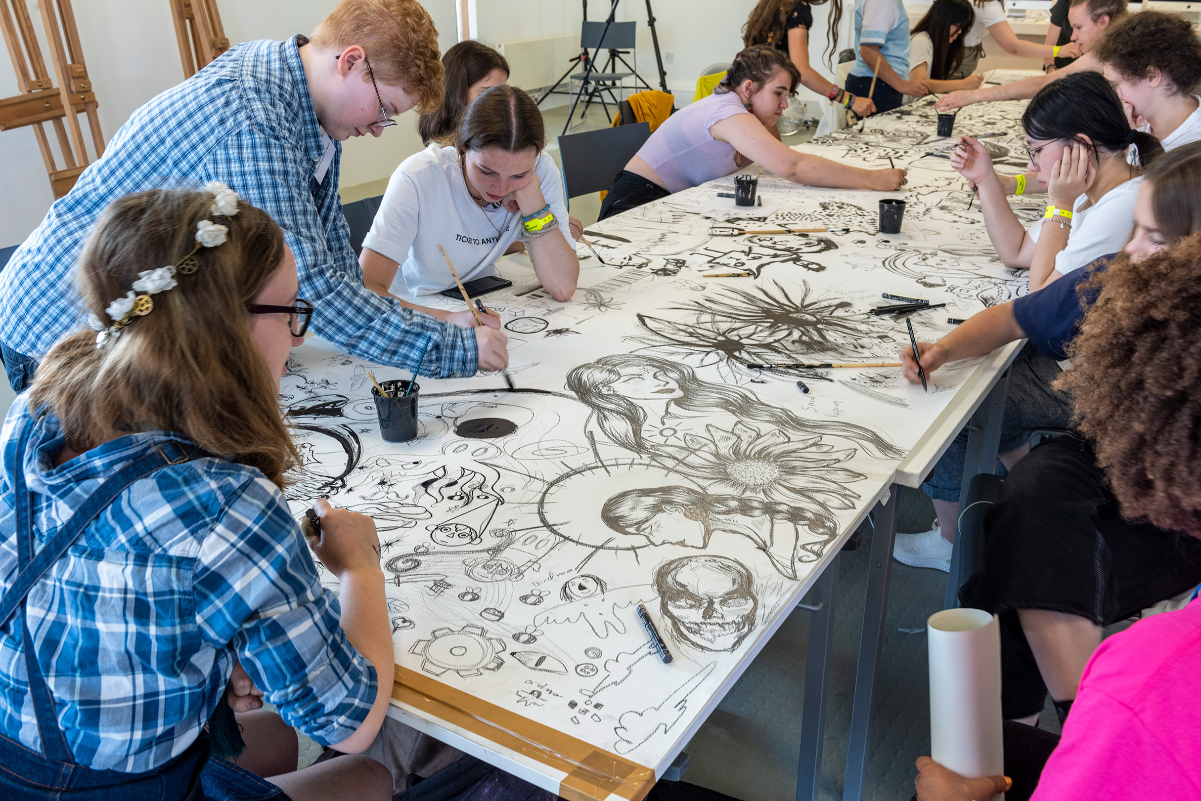 Group of students drawing on large canvas