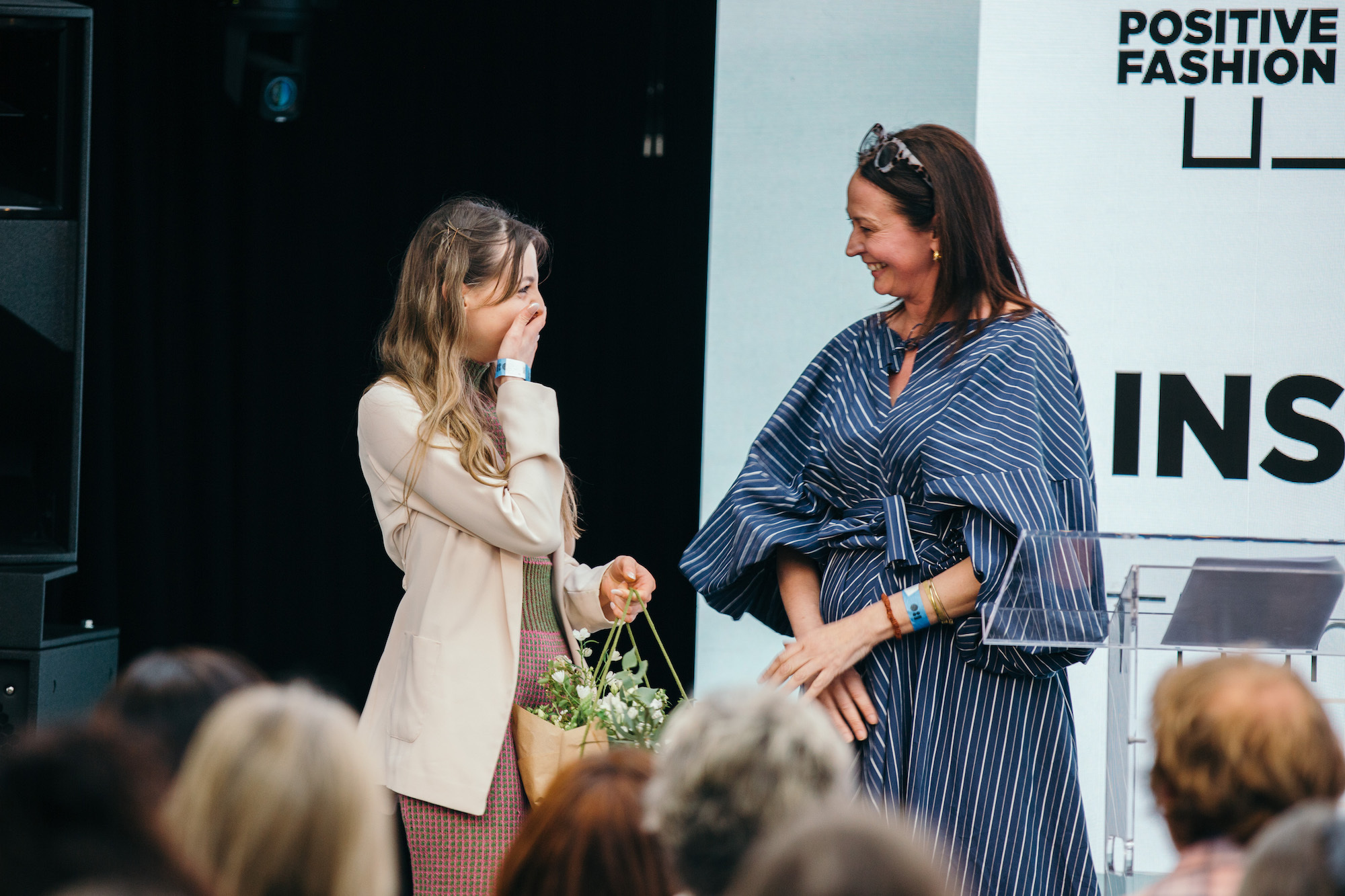 Person accepting a basket of flowers at an awards ceremony from a host at IPF.