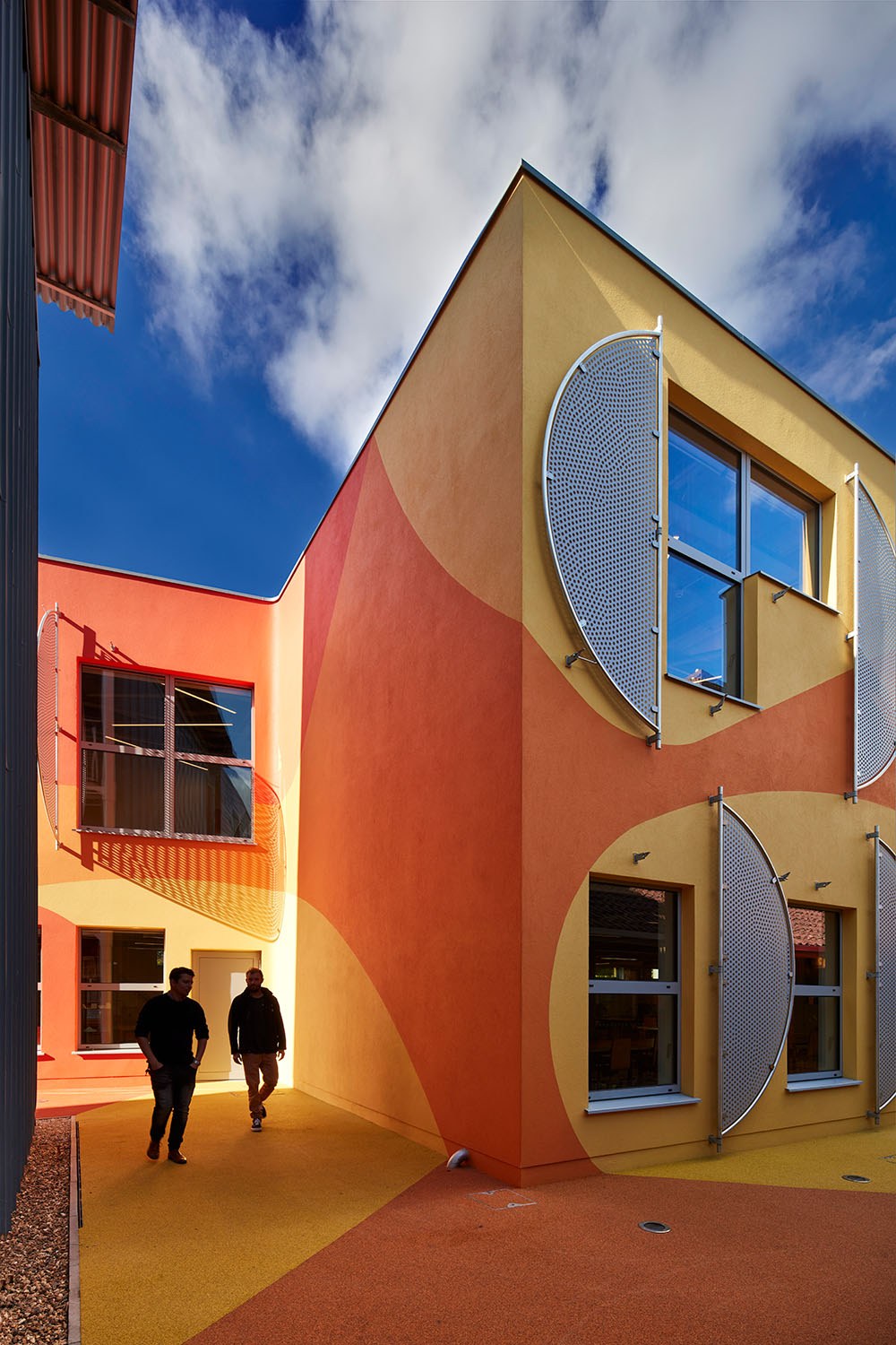 Front elevation of the Innovation Studio. Two students walking up to it.
