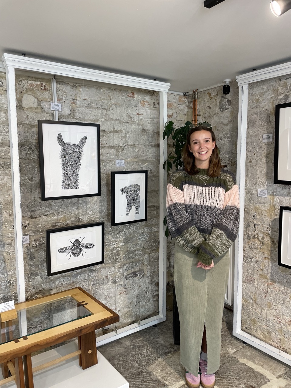 Pia Elliot stood by her work at her Intricate Wilderness gallery wearing a cosy sweater and glasses.