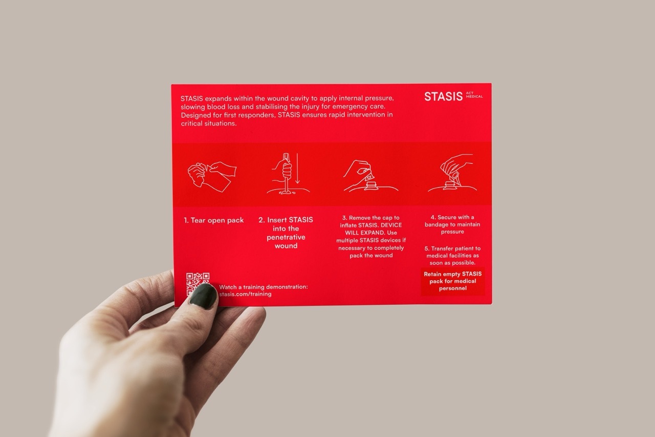 Red introductory instruction card for how to use STASIS with white text and diagrams. Instructions read: '1. Tear open pack. 2. Insert STASIS into the penetrative wound. 3. Remove the cap to inflate STASIS. DEVICE WILL EXPAND. Use multiple STASIS devices if necessary to completely pack the wound. 4. Secure with a bandage to maintain pressure. 5. Transfer patient to medical facilities as soon as possible.'