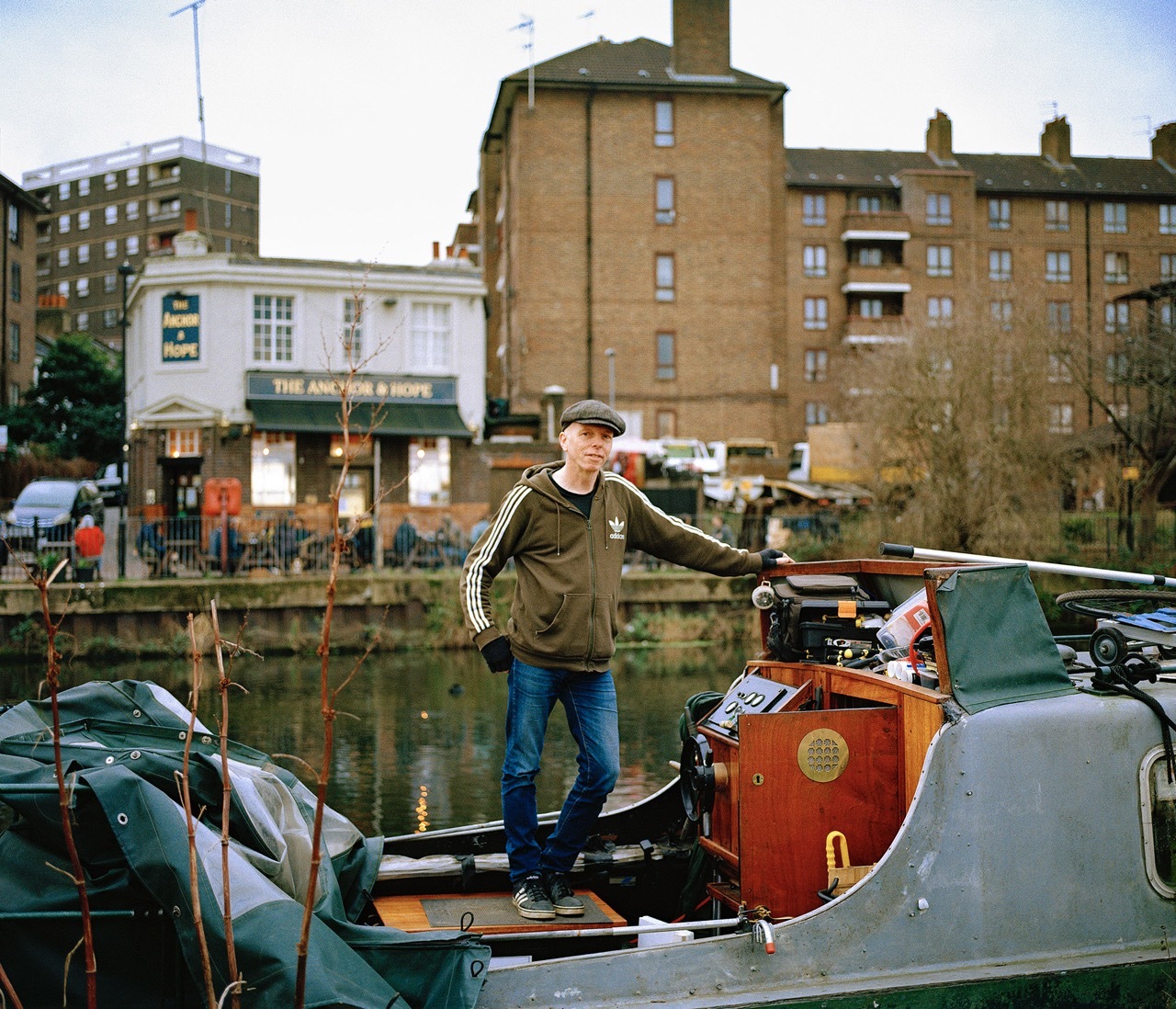 Man standing on a boat. River in the background.