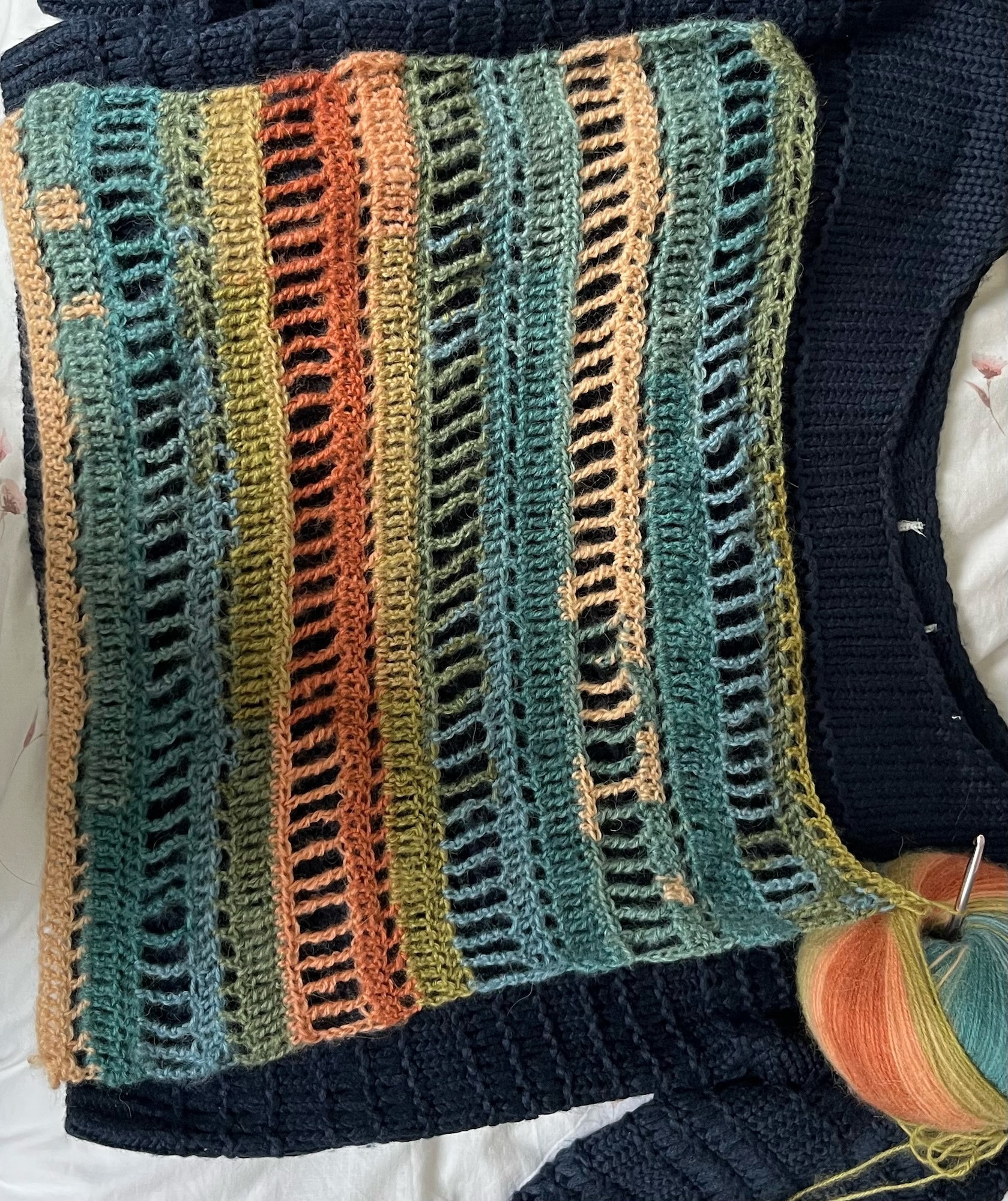 Part of a crochet scarf made up of multi-coloured layers of yarn.