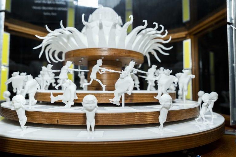 Three rows of 3D figures on round platforms moving in alternate directions.