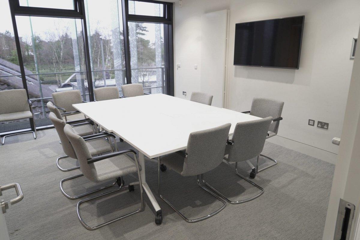 Meeting room with table, chairs and a TV