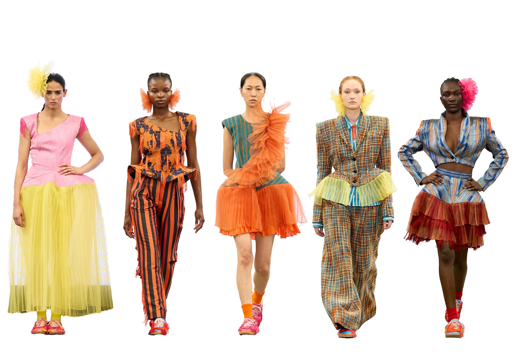 Five models wearing colourful fashion looks stand in a row against a white studio background.