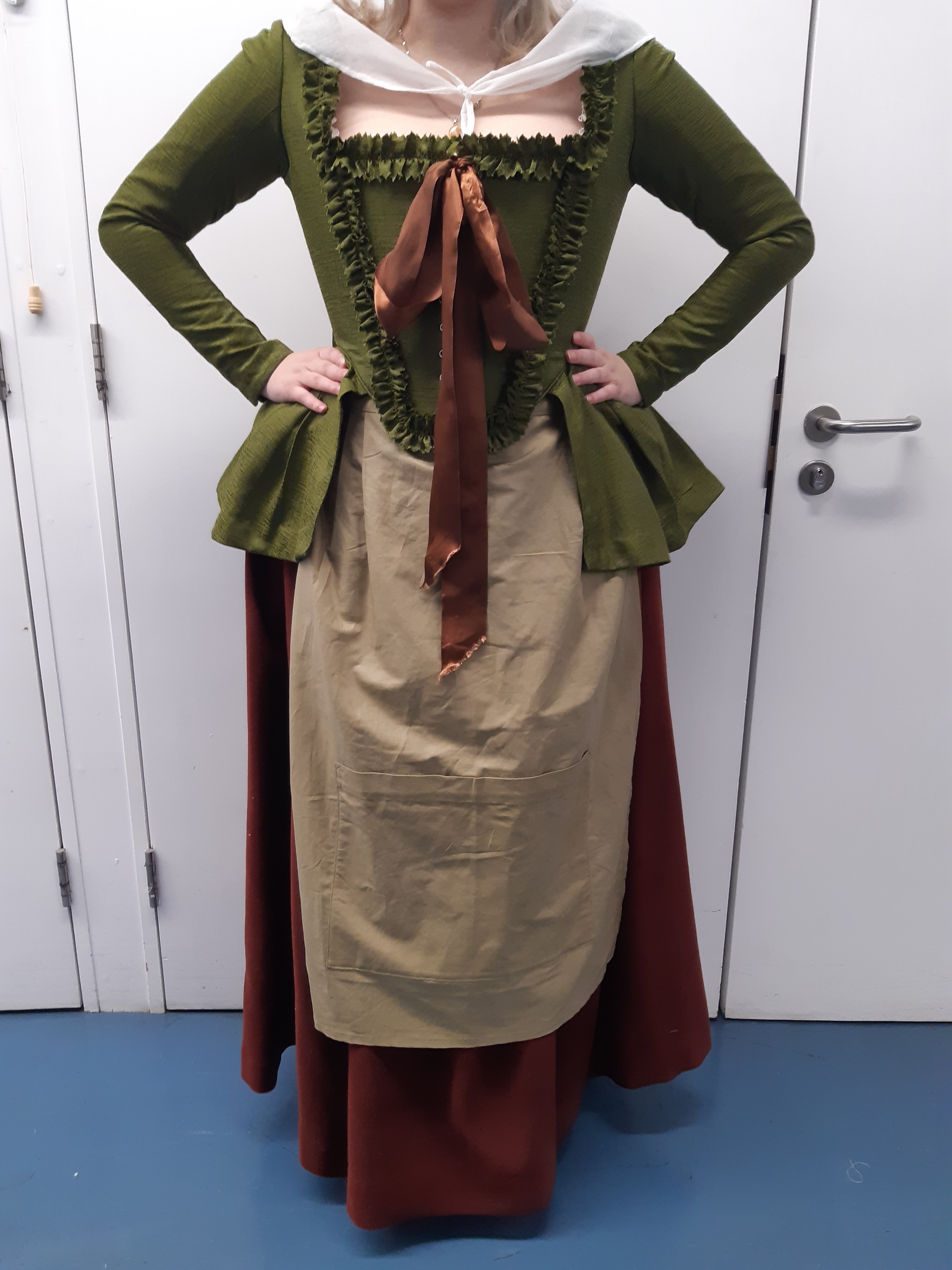 A French Revolution female peasant costume designed by a BA (Hons) Costume student viewed from the front. The model poses with their hands on their hips.