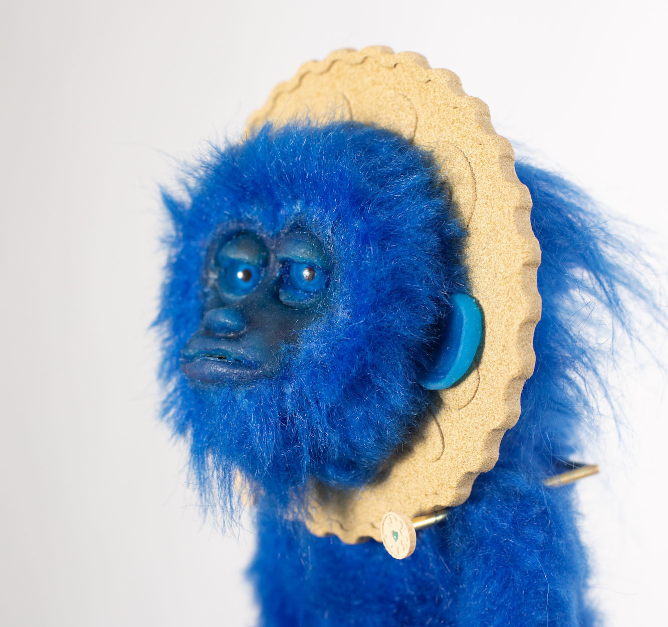 Animatronic puppet of a blue monkey with a Jammie Dodger biscuit behind its head.