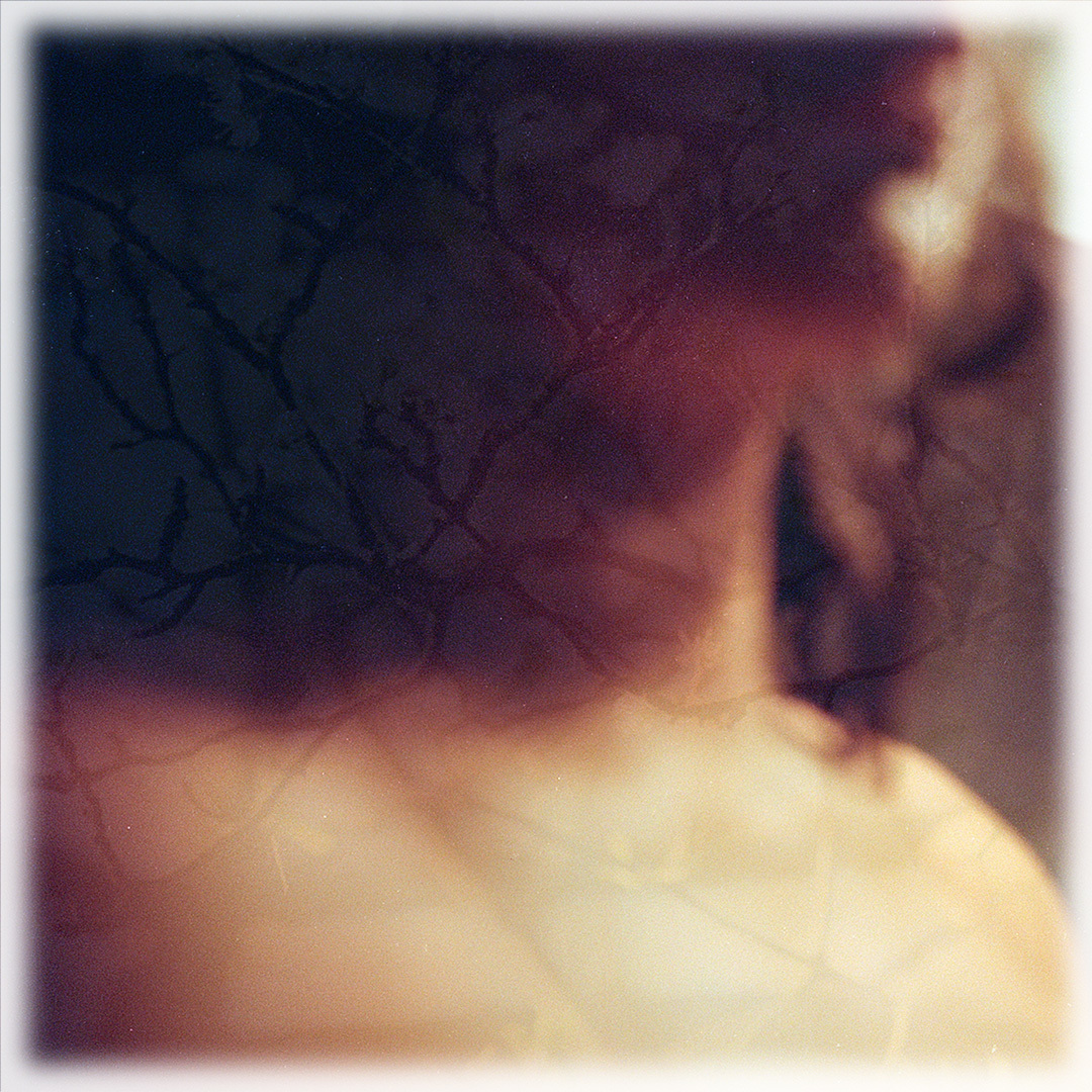 Blurred close-up of a person's head, neck and chest.