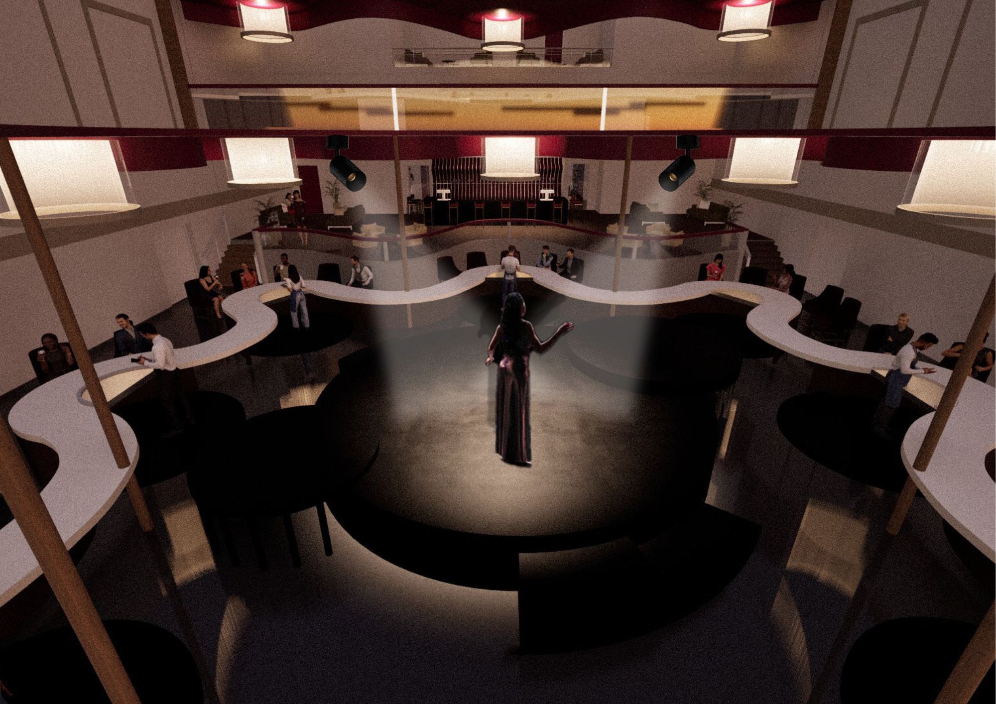 An elevated view of a modern performance space featuring a circular stage at the centre. A person in a black outfit stands on stage with arms raised, while a seated audience surrounds the stage on curved seating. Soft lighting illuminates the space.