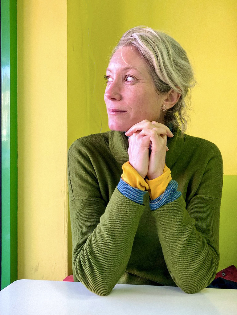 Jennie Savage wearing a green sweater, green background.