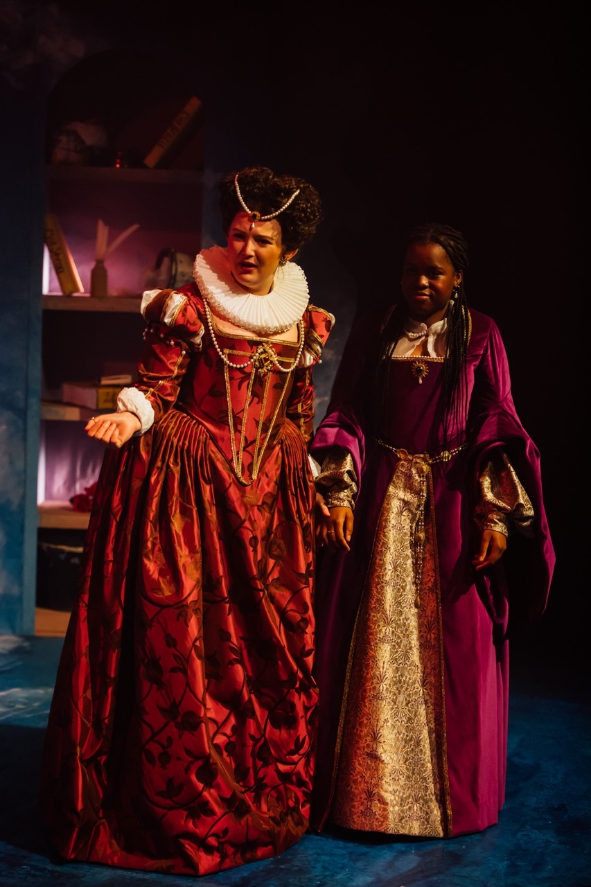 Mary Sidney, portrayed by Sarah Astbury, and Emilia 2, played by Kimberly Msawka. I made Mary Sidney’s red Elizabethan gown and ruff. Her gown is a crimson colour, printed with pomegranates and vines. The bodice is trimmed with gold braid and pearls.