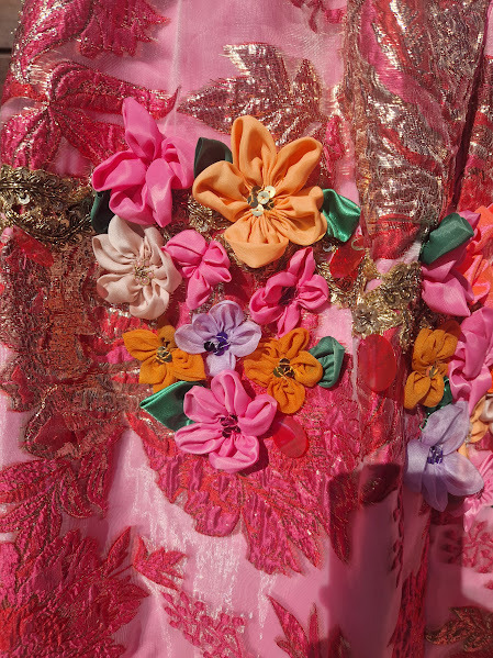 Tisbe’s Dress For La Cenerentola. Made of bright pink Brocade and backing with a contrasting boned bow, 200 handmade flowers and thousands of sequins.