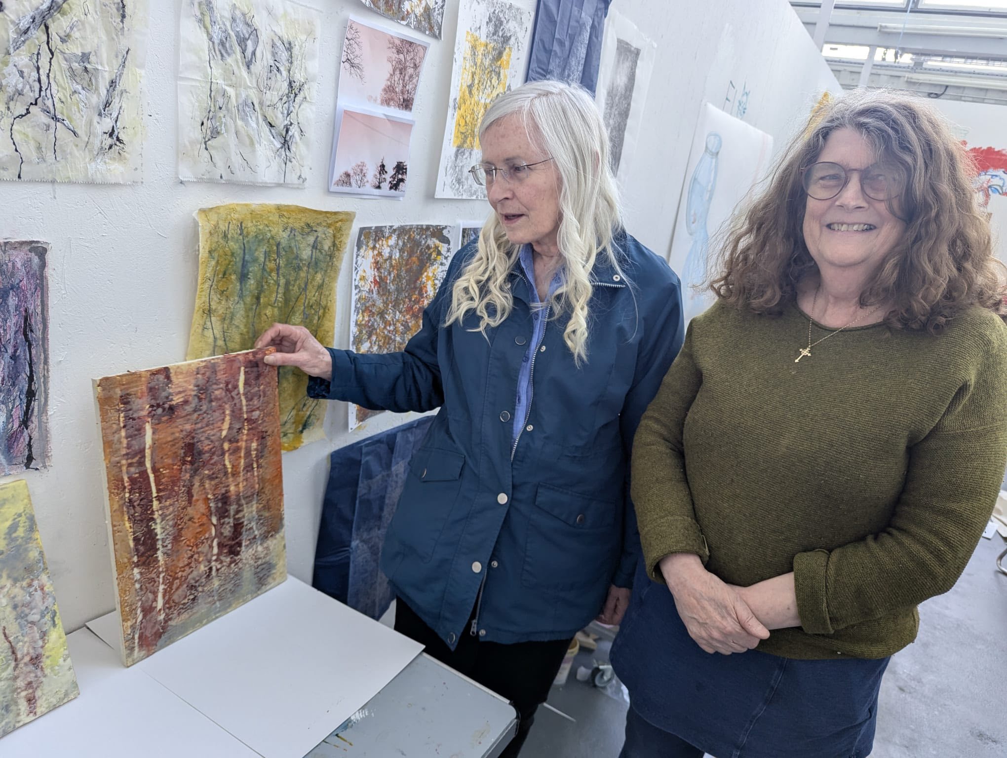Julia stood by an artist, admiring canvasses of abstract paintwork in the studio.