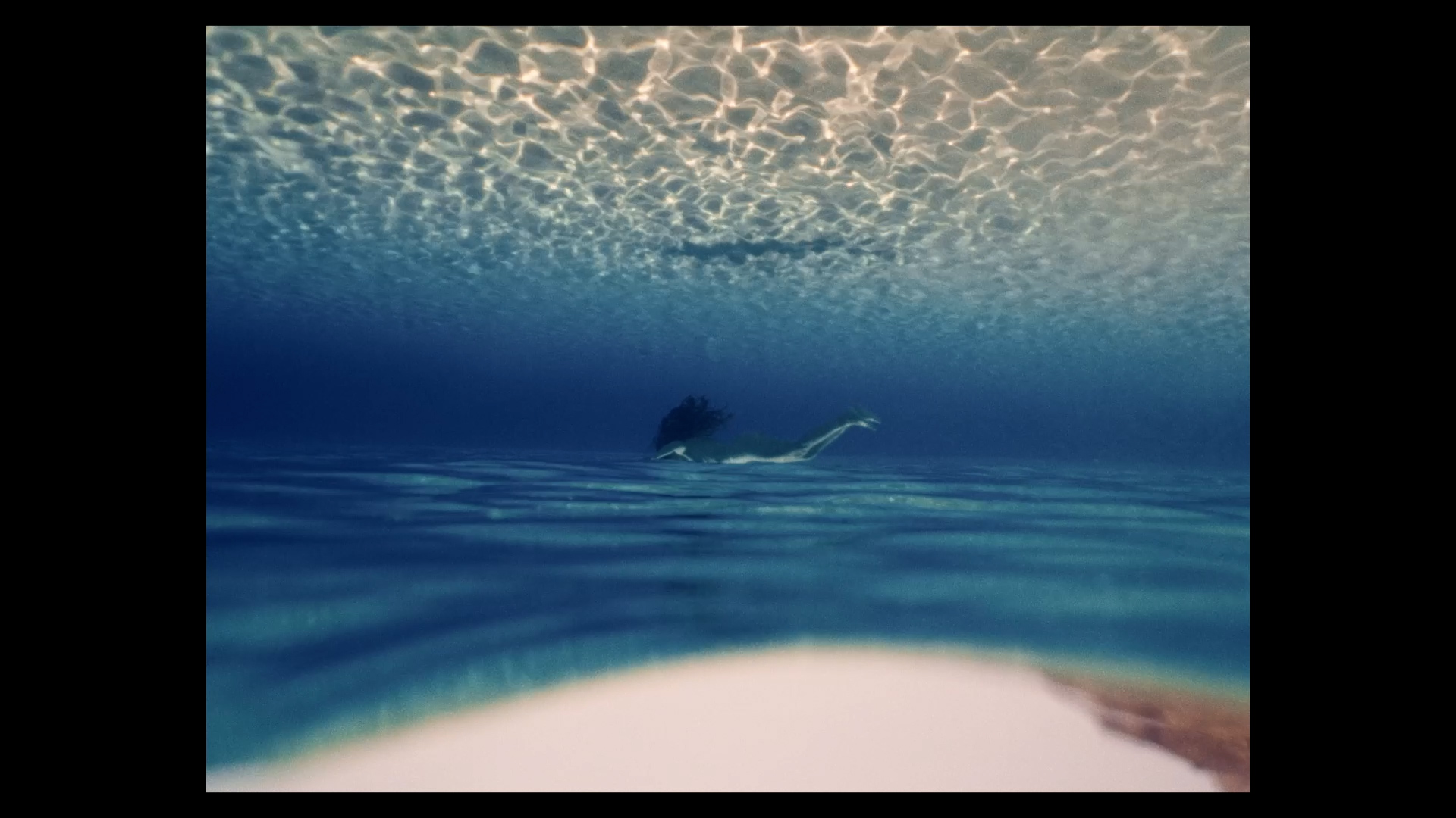 Film still of a person swimming underwater