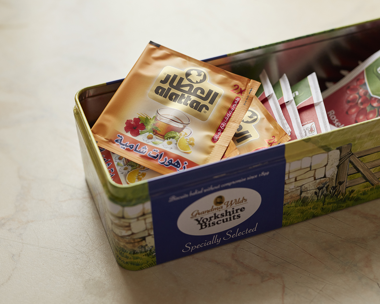 Box of tea bags in packets, kept in a sweet tin.