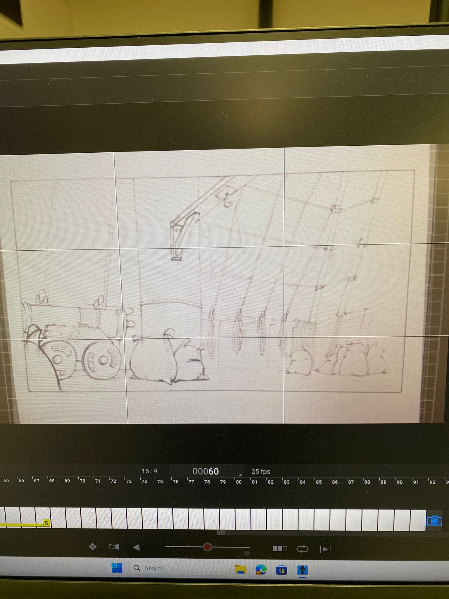 A computer monitor with animation software open. The screen shows a line drawing of the deck of a ship with rigging, ropes, a mast, a cannon and several sacks.