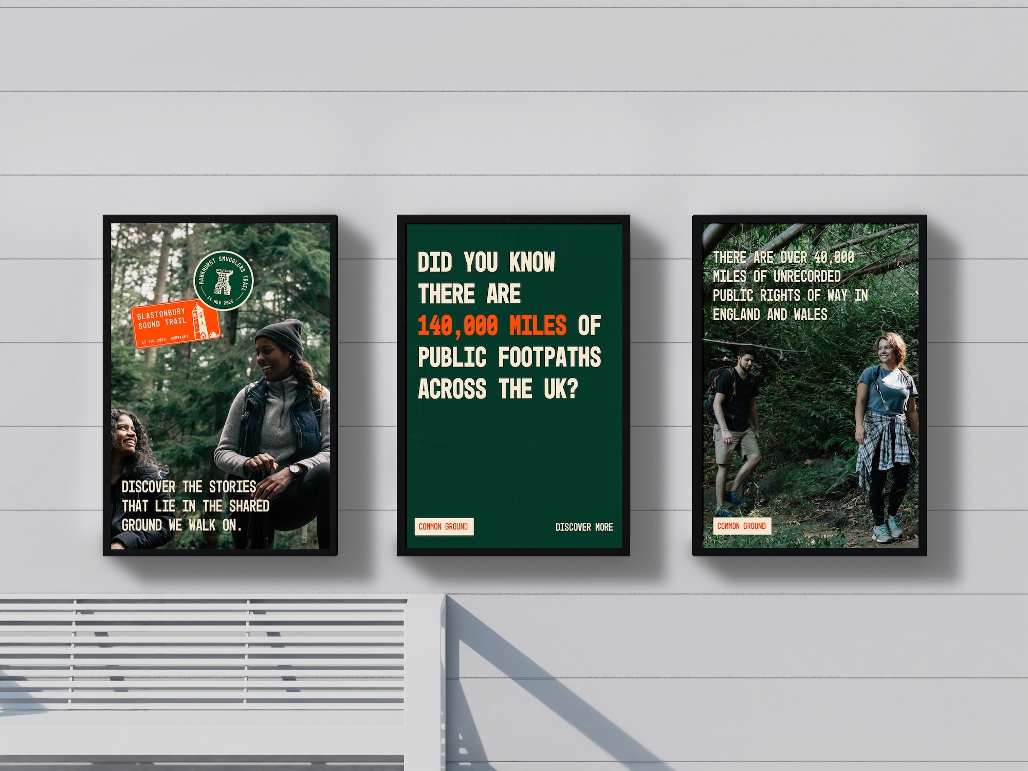 Three framed posters on white wall: left shows person in forest with text, centre has green background with white text about public footpaths, right shows person walking in woodland.