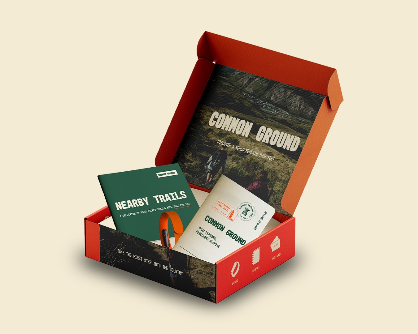 Open red cardboard box containing green and white printed materials, coffee packaging, and branded items on cream background.