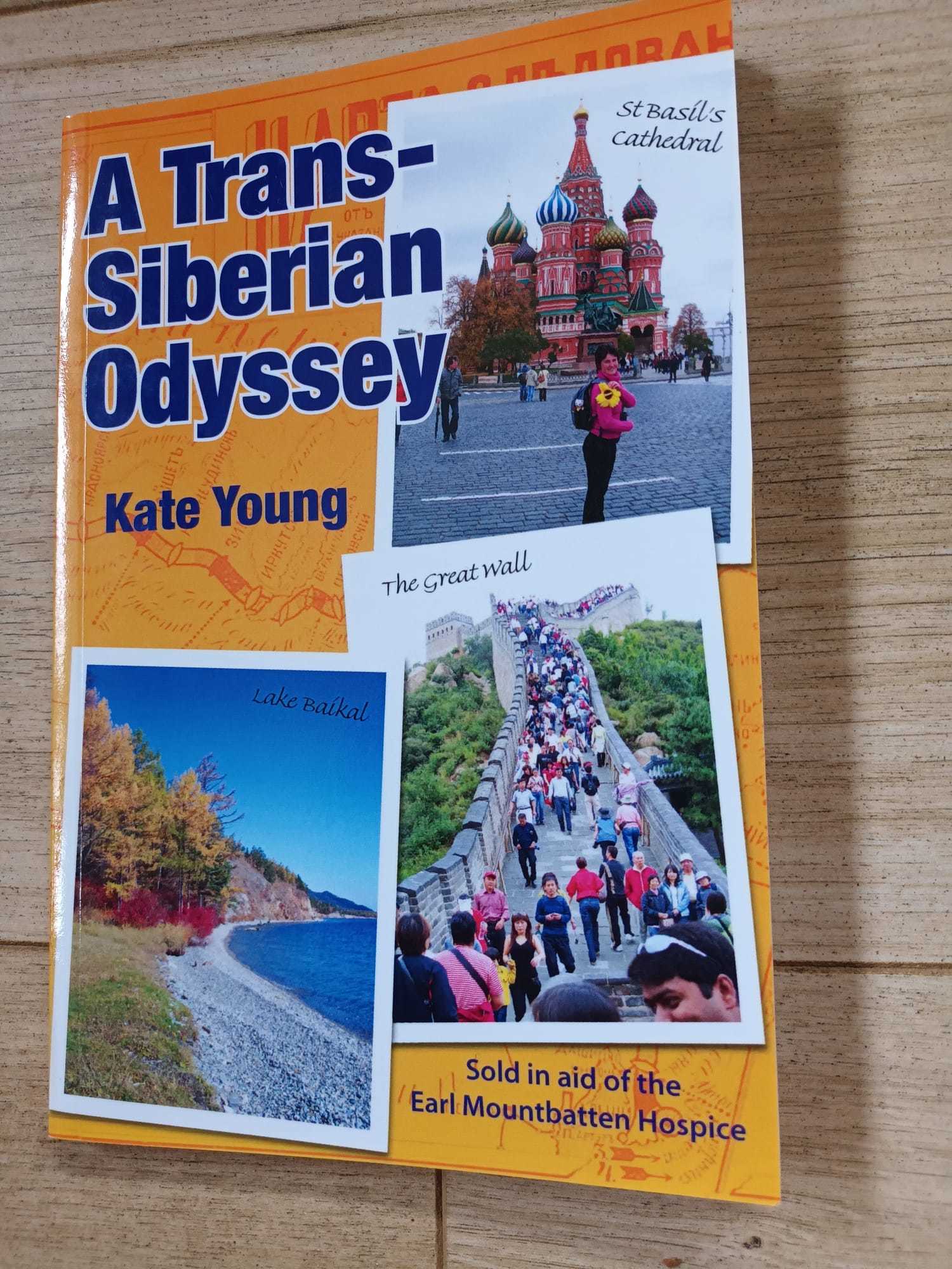 Front cover of "A Trans-Siberian Odyssey" by Kate Young displayed on a wooden background.