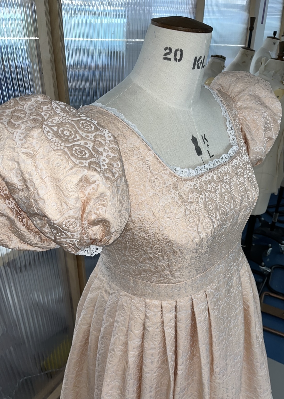 Up-close view of the 1824 Blandford Museum replica dress. Focusing on the details of the beret sleeves and intricate detailing of the fabric.