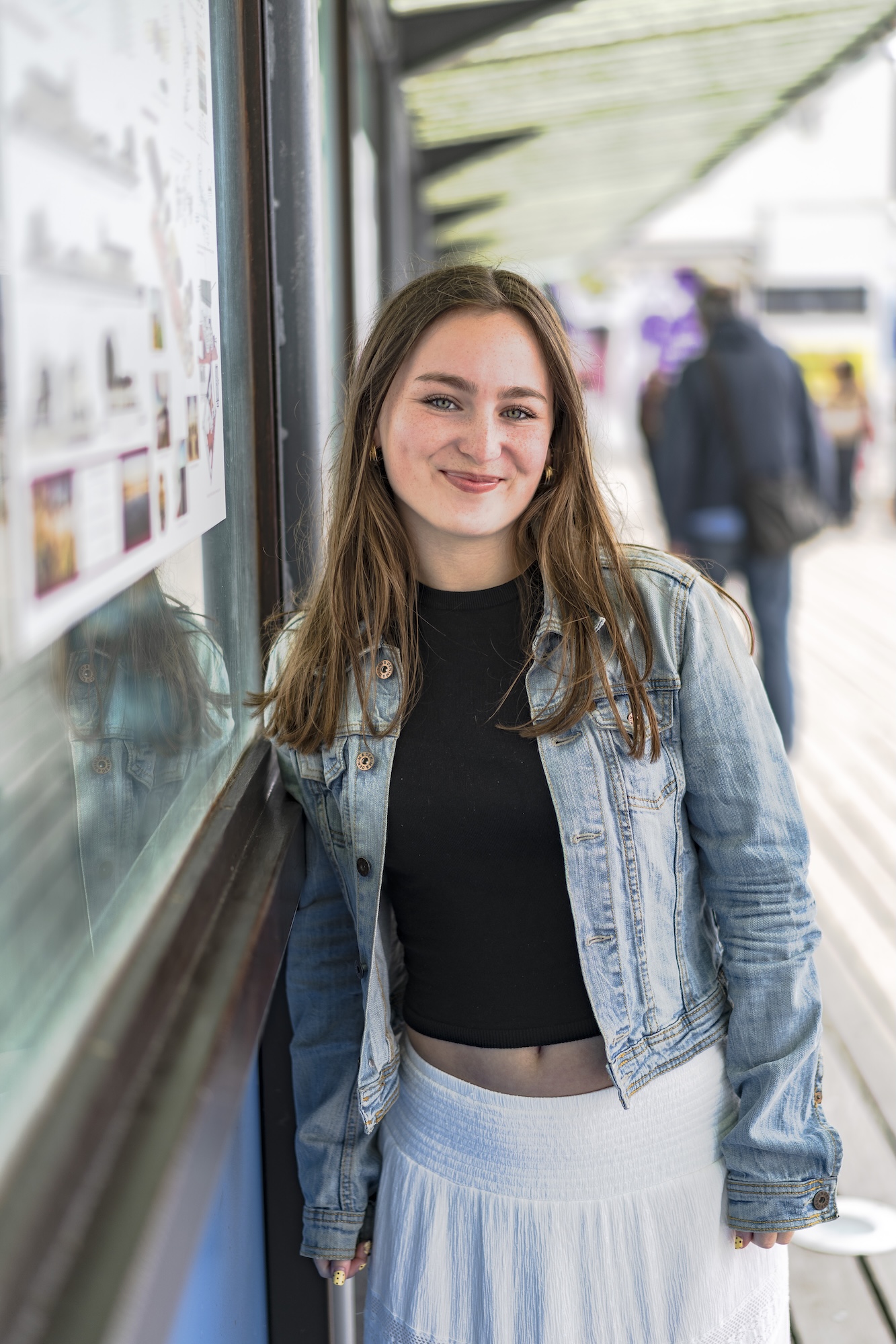 Portrait of K White standing next to a display board on Bournemouth Pier.