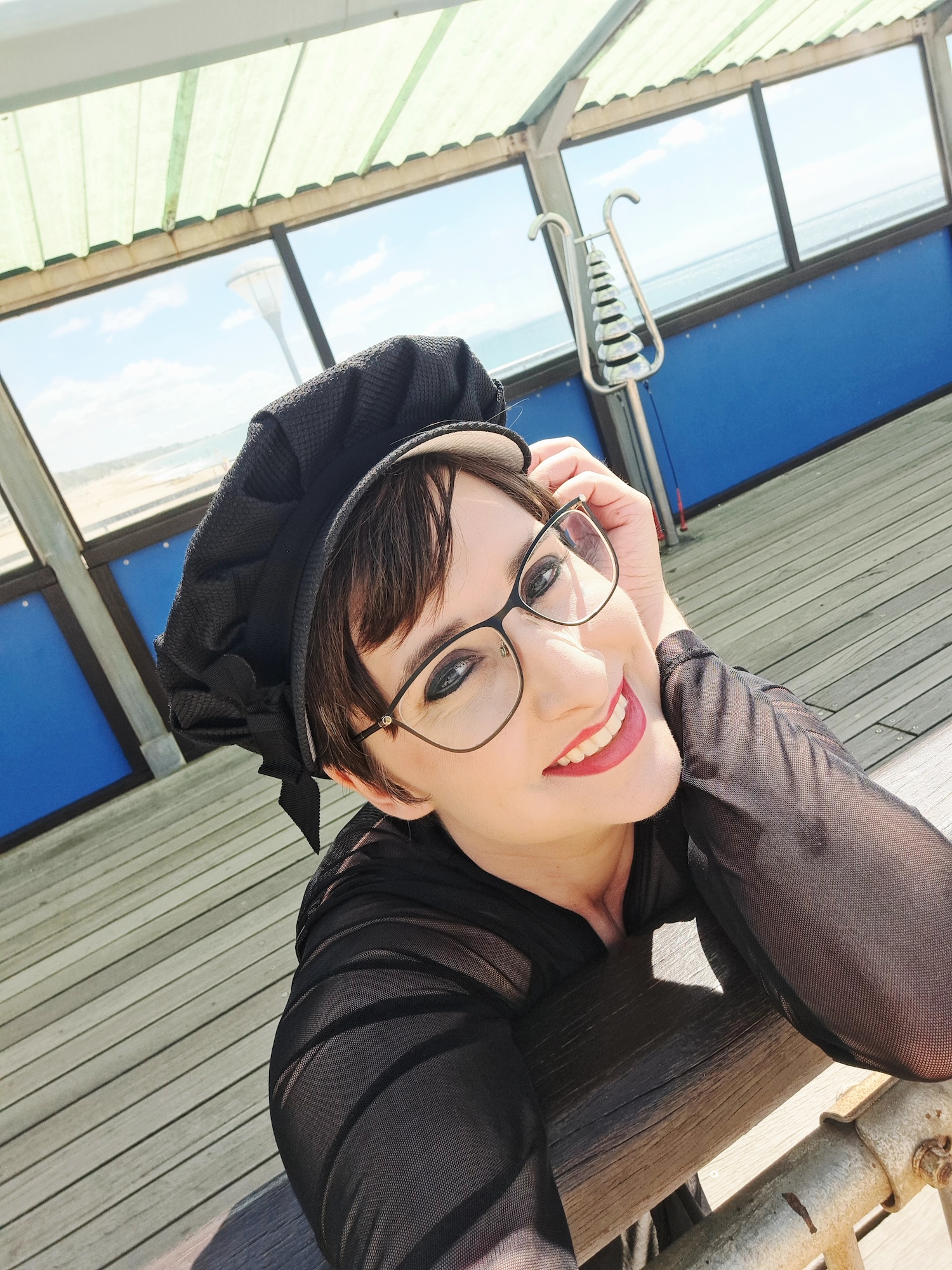 Selfie of K Williams smiling while wearing a black Stephen Jones hat on Bournemouth Pier