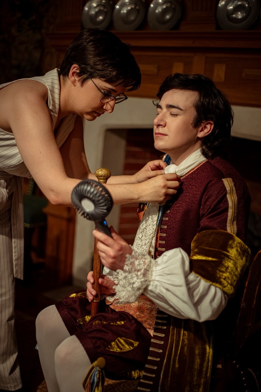 Costumer Kelsey Williams adjusts the cravat of model Tyler Whiting as they take a break during their photography session. The photoshoot is of 17th-century menswear in the Museum of the Home in London.