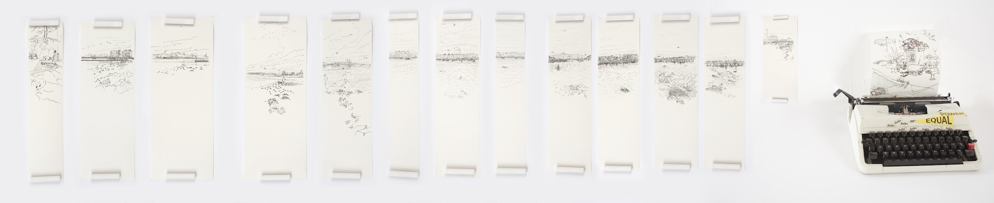 A series of 14 typed drawings on long sheets of paper of varying widths. 13 of the drawings are lined up, while the 14th sits in a typewriter.
