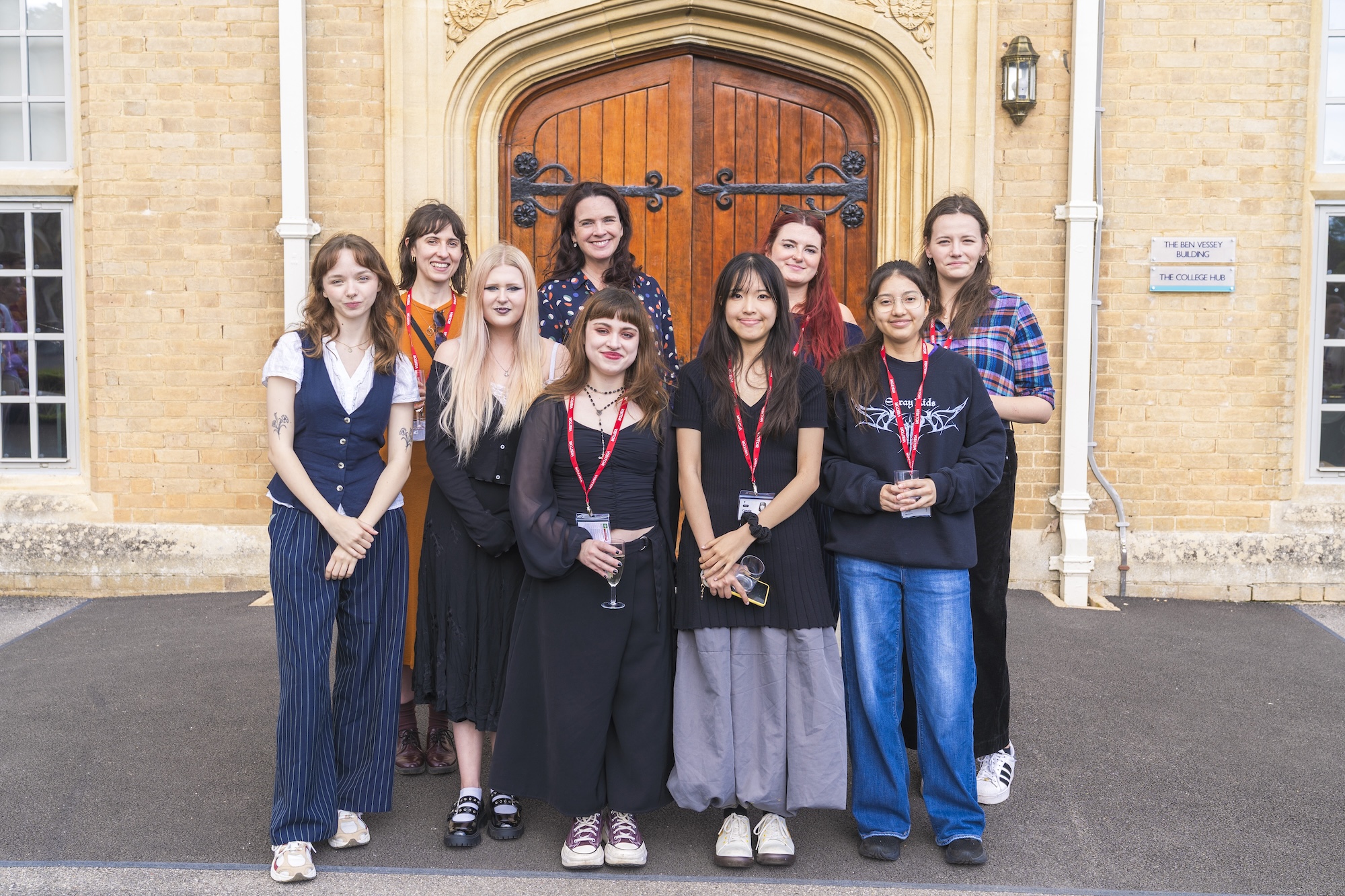 A group of Arts University Bournemouth students and staff, and Canford School staff, posing for a photo outside the main doors of Canford School