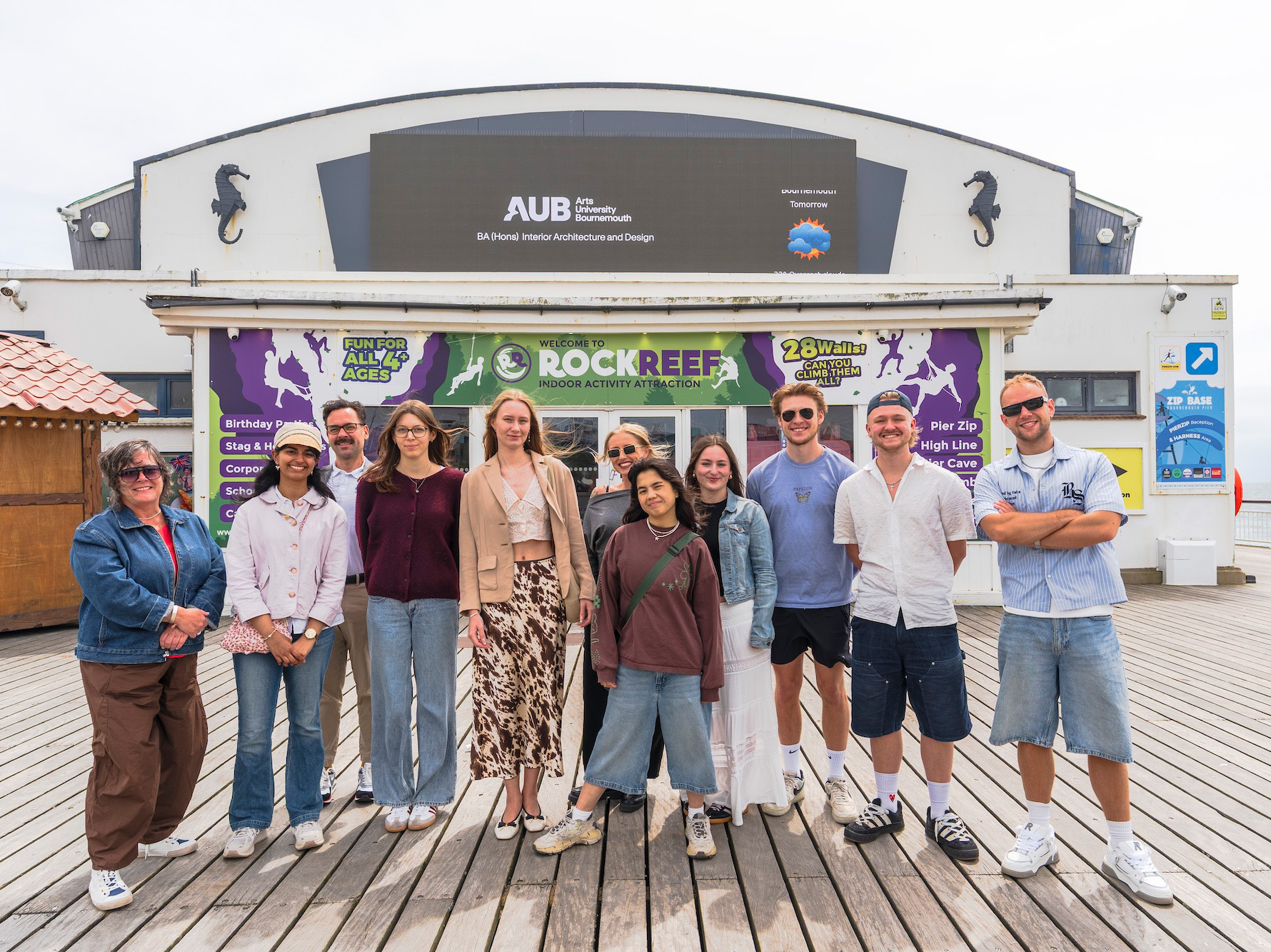 BA (Hons) Interior Architecture and Design students and staff grouped on Bournemouth Pier and posing for a photo.