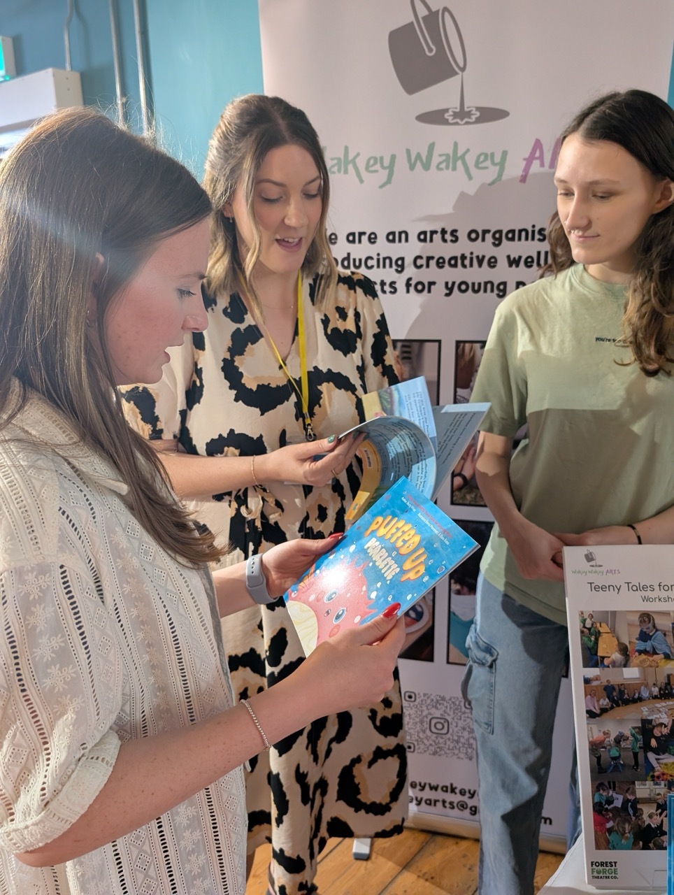 Emma Watremetz, Becky White and Elana Evans holding copies of Puffed Up Pearlette and reading them.