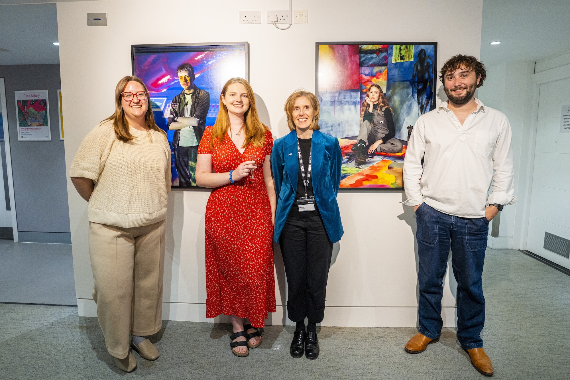 R Virgo, E McEvoy, K Bird and H Davenport pose in front of two prints from the Arts University Bournemouth 2027 prospectus Archetypes deck.