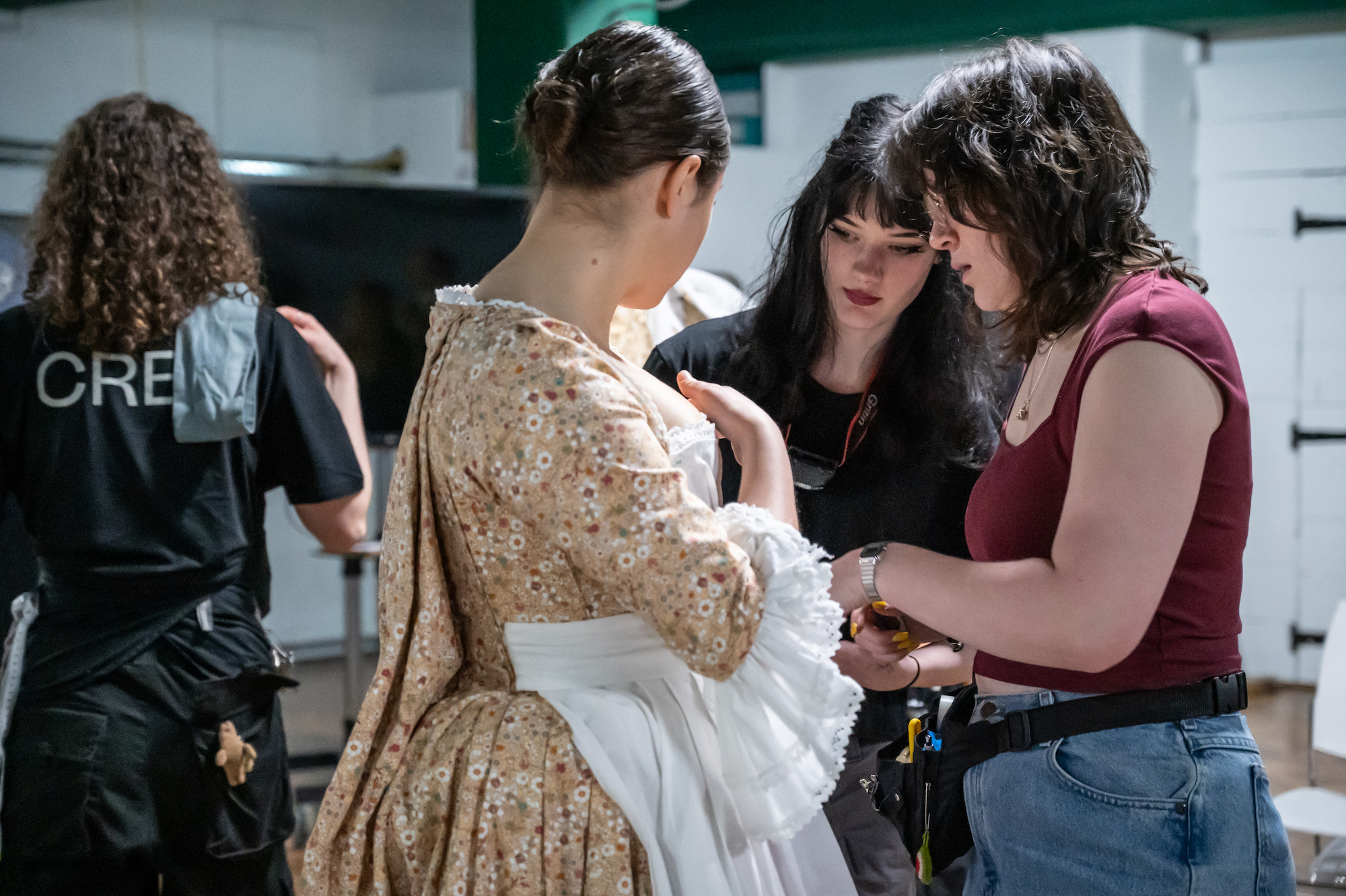 BA (Hons) Costume students adjusting a BA (Hons) Acting student's costume backstage at Palace Court Theatre during a performance of La Casa Nova.